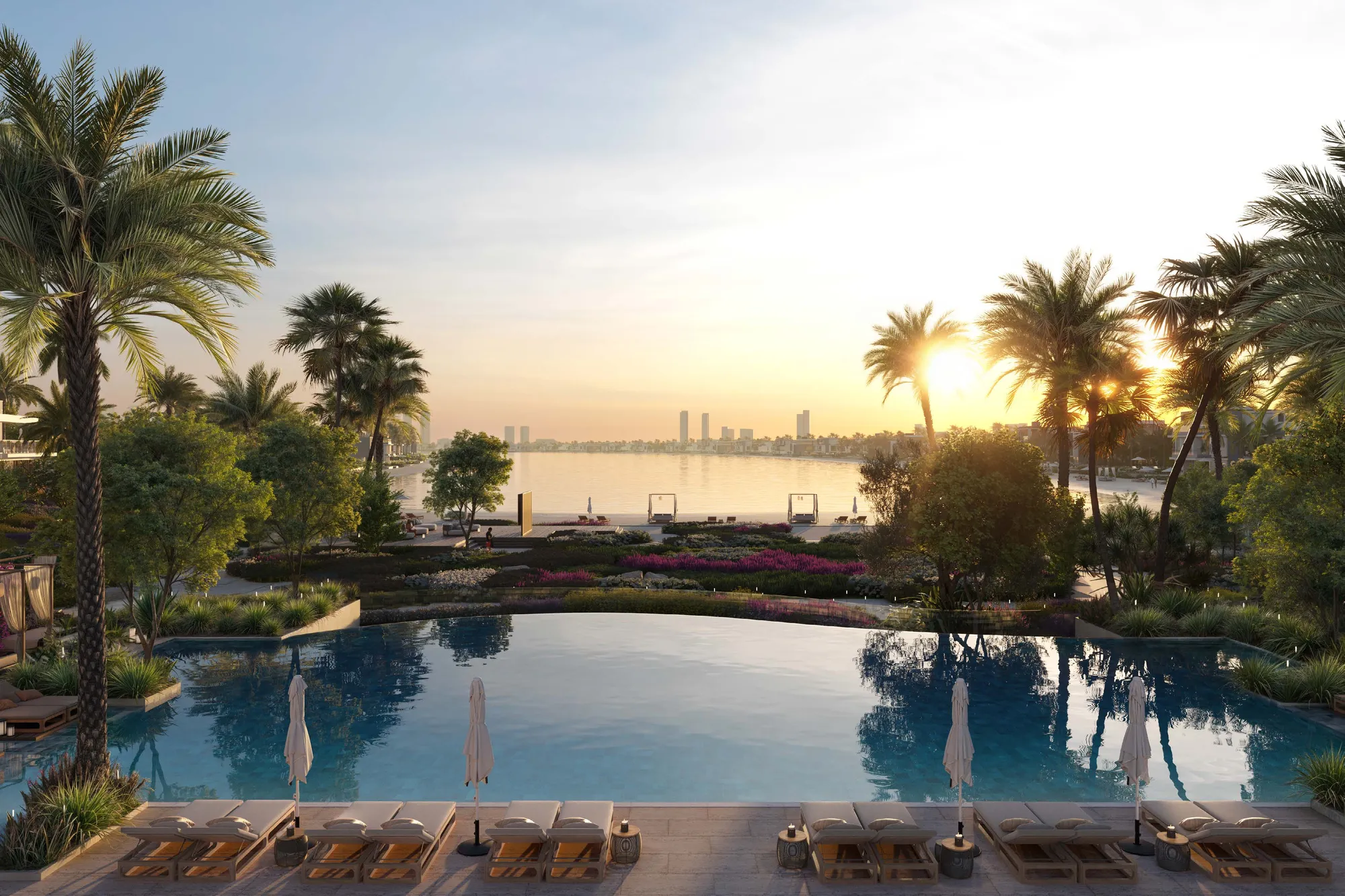 Infinity pool with sun loungers, gardens and the bay at sunset