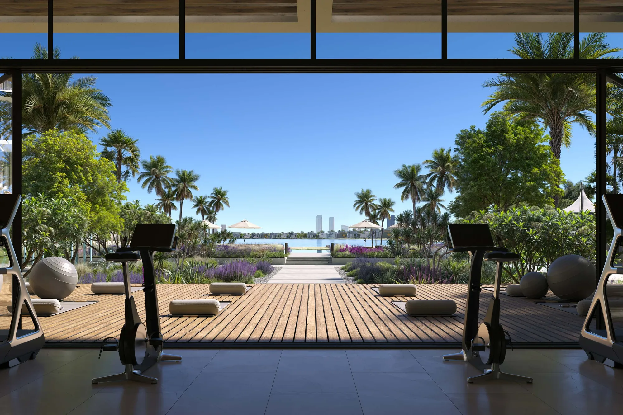 Gym with bikes opening onto a timber deck and a garden path to the water