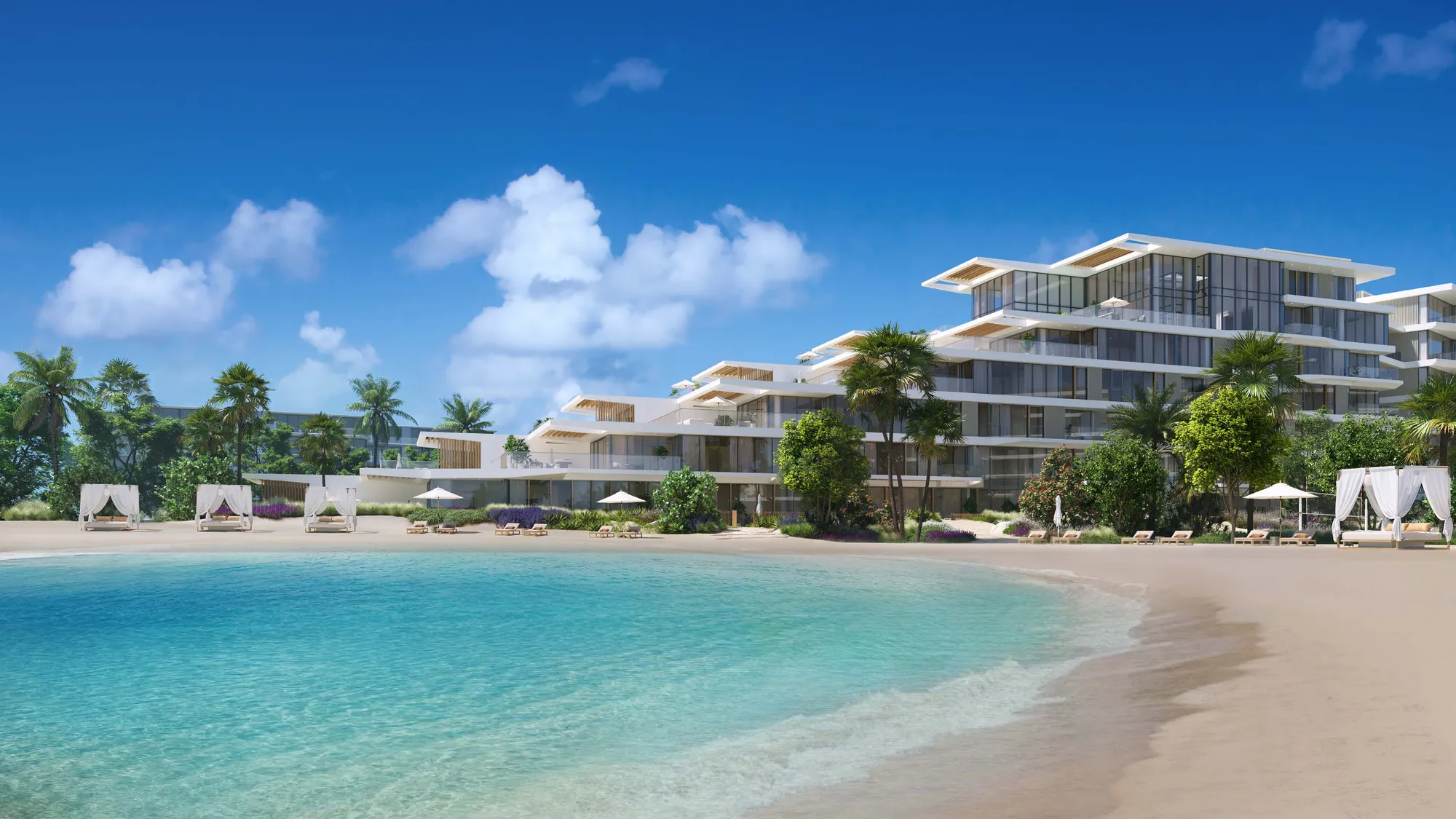 Stepped white building behind palms, cabanas and a curving turquoise beach